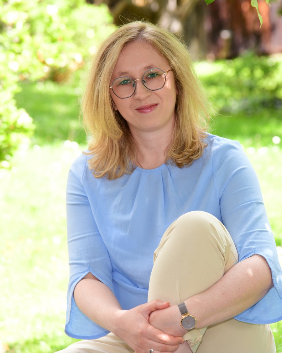 Miriam Althaler sitzt im Garten und lächelt in die Kamera